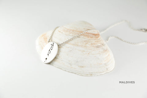 Small oval pendant shown in sterling silver in matte finish with chain and Maldives border.