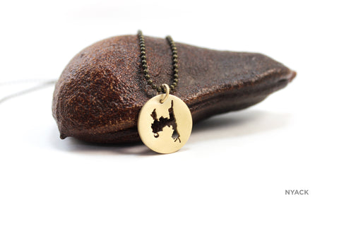 Small brass medallion of The Nyacks with matte finish on oxidized chain.
